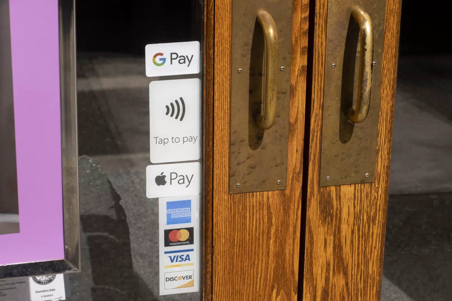 Portland, OR, USA - Apr 1, 2022: Various payment options including Google Pay, Apple Pay, AMEX, MasterCard, Visa, and Discover, are seen advertised at the entrance to a restaurant in Portland, Oregon.